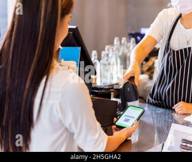 Technologie et paiement.Jeune femme utilisant le paiement sans fil ou sans contact par téléphone intelligent. Banque D'Images