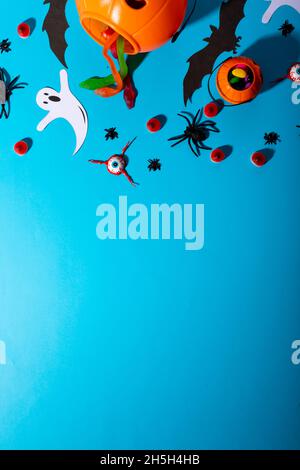 Vue rapprochée de plusieurs bonbons et jouets d'halloween sur fond bleu Banque D'Images