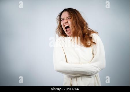 Portrait en gros plan d'une femme aliénée en blouson sur fond blanc. Banque D'Images