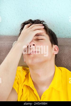 Triste jeune homme sur le canapé à la maison Banque D'Images