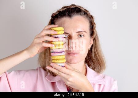 Portrait de femme authentique avec macarons entre les mains. Photo de style de vie de confiseur. Banque D'Images