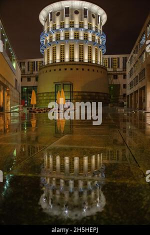 STUTTGART, ALLEMAGNE - 08 juin 2021 : le reflet de l'Université d'État illuminée de musique et des arts de la scène de Stuttgart sur un sol humide Banque D'Images