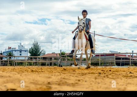 Femme prenant des cours d'équitation dans un enclos Banque D'Images