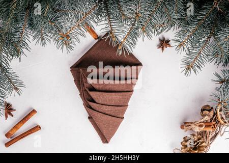 Didacticiel étape par étape : pliez la serviette en lin en forme d'arbre de Noël.Réglage du tableau de la nouvelle année.Étape 6 : pliez le deuxième côté pour créer un coin vif.Vue de dessus Banque D'Images