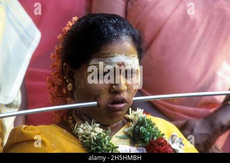 Femme perçant la tige de fer à travers les joues déchargeant le vœu, festival Mariamman à Coimbatore, Tamil Nadu, Inde Banque D'Images