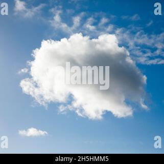 Un seul nuage de fleecy, ainsi que quelques nuages de plumes, ornent le ciel bleu dans des vents forts Banque D'Images