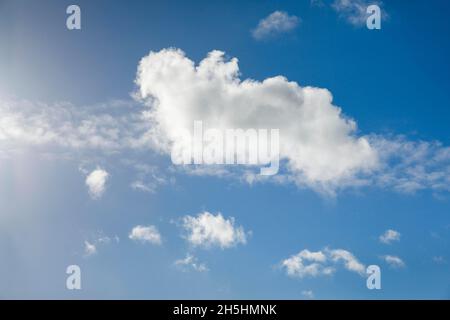 Un seul nuage de fleecy, ainsi que quelques nuages de plumes, ornent le ciel bleu dans des vents forts Banque D'Images