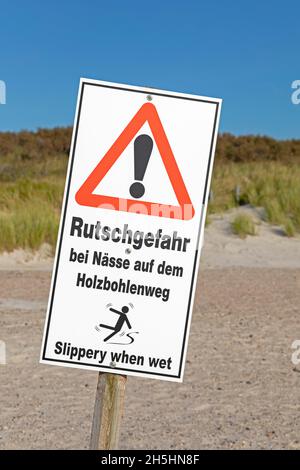 Signe d'avertissement de risque de glisser sur le chemin de la planche en bois quand humide, Duene, île Helgoland, Schleswig-Holstein, Allemagne Banque D'Images