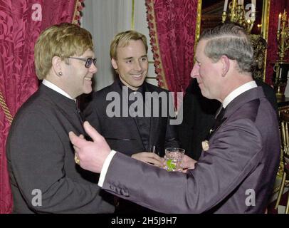 Photo du dossier datée du 12/3/2001, du Prince de Galles (R) parlant au chanteur Sir Elton John et à son associé David meunter (au centre), lors d'un dîner pour célébrer le 25e anniversaire de la fondation Prince's Trust au Palais St James, à Londres.Les deux se sont réunis à nouveau lors d'une investiture du château de Windsor où le prince a fait du musicien un membre de l'ordre des compagnons d'honneur.Date de publication : le mercredi 10 novembre 2021. Banque D'Images