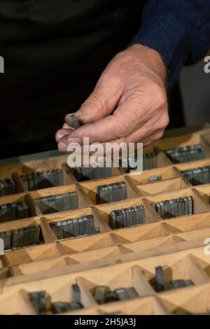 Lettres alphabet blocs en métal dans la main Old Man Banque D'Images