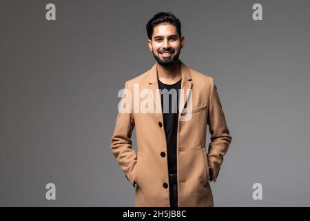 Portrait en gros plan d'un jeune homme d'affaires indien souriant sur fond gris Banque D'Images