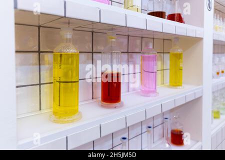 Armoire de laboratoire avec flacons, flacons et tubes colorés contenant des médicaments liquides. Banque D'Images