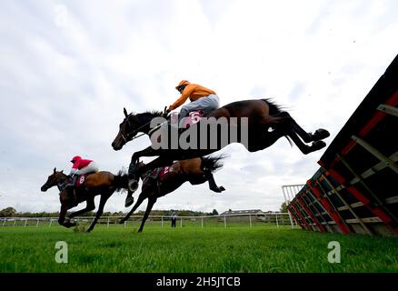 Saint Segal, monté par le jockey Chester Williams (silks orange), se met à franchir un obstacle sur le chemin de la victoire des dix à suivre à l'obstacle tote.co.uk Juvenile Maiden à l'hippodrome de Bangor-on-Dee.Date de la photo: Mercredi 10 novembre 2021. Banque D'Images