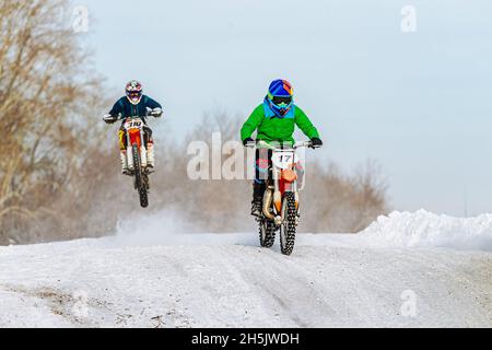 deux motocyclistes sur piste enneigée en motocross d'hiver Banque D'Images