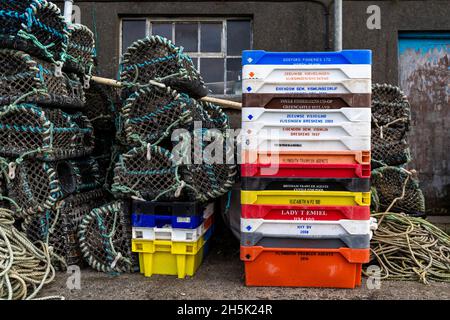 Pots de homard et boîtes à poissons empilés à l'extérieur d'une maison à poissons.Newlyn Harbour, Cornwall.ROYAUME-UNI Banque D'Images