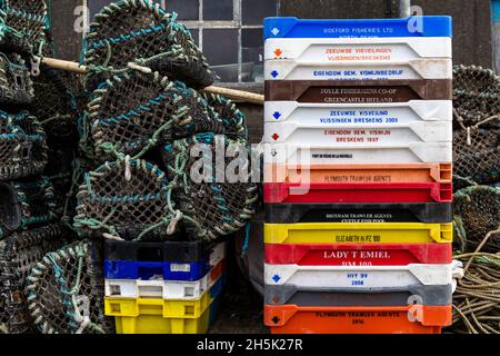 Pots de homard et boîtes à poissons empilés à l'extérieur d'une maison à poissons.Newlyn Harbour, Cornwall.ROYAUME-UNI Banque D'Images