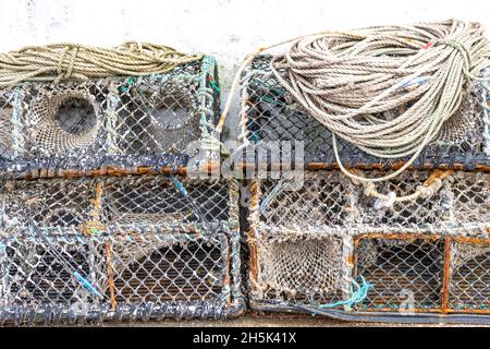 Pots de homard empilés à l'extérieur d'une maison de poissons, Newlyn Harbour, Cornwall.ROYAUME-UNI Banque D'Images
