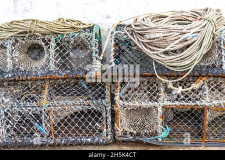 Pots de homard empilés à l'extérieur d'une maison de poissons, Newlyn Harbour, Cornwall.ROYAUME-UNI Banque D'Images
