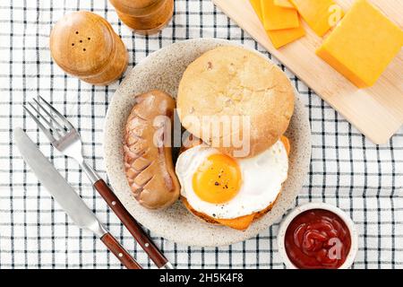 Sandwich au fromage et à l'œuf avec saucisse de porc, vue de dessus.Petit déjeuner anglais Banque D'Images