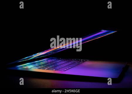 un ordinateur portable à moitié fermé, lumineux et lumineux Banque D'Images