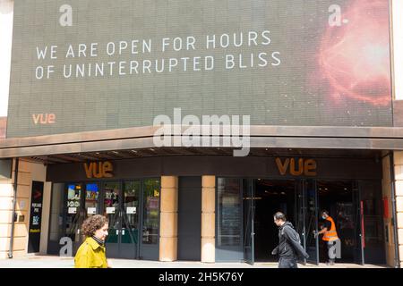 Les gens marchent devant un message affiché au-dessus des portes ouvertes d'un cinéma vue à Londres, car les salles intérieures telles que les musées et les cinémas sont autorisées à rouvrir. Banque D'Images