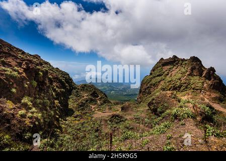 Randonneurs debout au sommet des falaises rocheuses du volcan, la Soufrière surplombant la campagne sur la Basse-Terre ; Guadeloupe, Antilles françaises Banque D'Images