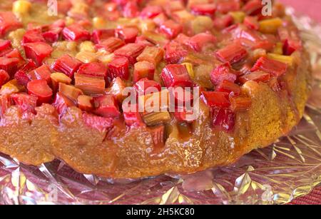 Gâteau renversé à la rhubarbe avec glaçage au sucre brun sur un plateau en cristal. Banque D'Images