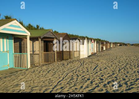 Cabanes en bois peint sur la plage le long du front de mer, East Head, West Wittering, Royaume-Uni Banque D'Images