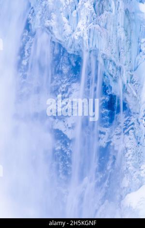 L'eau glacée des chutes inférieures au Grand Canyon de Yellowstone avec des formations de glace congelées sur les falaises du parc national de Yellowstone en hiver Banque D'Images