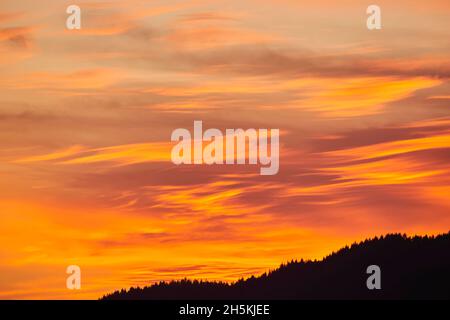 Coucher de soleil doré nuages dans le ciel sur un paysage silhoueté; Bavière, Allemagne Banque D'Images