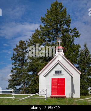 Une petite église de campagne blanche avec des portes rouges brillantes et une croix sur le dessus; Colombie-Britannique, Canada Banque D'Images