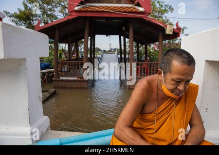 Nonthaburi, Thaïlande.10 novembre 2021.Un moine photographié devant le quai inondé du temple.après la tempête de Dianmu, la tempête tropicale de Lionrock et la tempête de Kompasu, 13 provinces ont été touchées par le niveau de la mer marémotrice qui a causé des inondations.Koh Kret une destination touristique culturelle connaissable, une communauté au bord de la rivière et une île à Nonthaburi sont quelques-unes des zones touchées.Crédit : SOPA Images Limited/Alamy Live News Banque D'Images