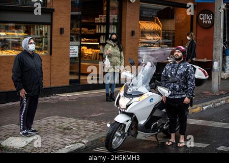 Un homme se tient à côté de sa moto et des gens sont vus debout devant un magasin pour observer un moment de silence pour Ataturk pendant le 83e anniversaire de sa mort à Istanbul.les gens sont en silence le 09 h 05, le temps de mort de Mustafa Kemal Ataturk, fondateur de la République de Turquie,Pendant le 83e anniversaire de sa mort, sur Acibaem à Istanbul.Les gens observent un moment de silence à 09 h 05, heure de la mort de Mustafa Kemal Ataturk, fondateur de la République de Turquie, lors du 83e anniversaire de sa mort, à Acibaem, à Istanbul. Banque D'Images