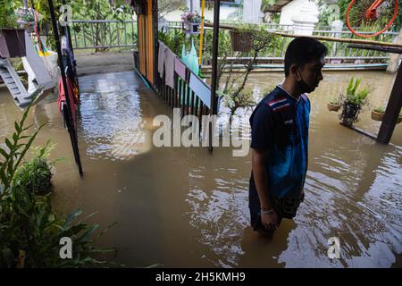 Nonthaburi, Thaïlande.10 novembre 2021.Un résident de Koh Kret vu debout dans son enceinte inondée.après la tempête de Dianmu, la tempête tropicale de Lionrock et la tempête de Kompasu, 13 provinces ont été touchées par le niveau de la mer marémotrice qui a causé des inondations.Koh Kret une destination touristique culturelle connaissable, une communauté au bord de la rivière et une île à Nonthaburi sont quelques-unes des zones touchées.Crédit : SOPA Images Limited/Alamy Live News Banque D'Images