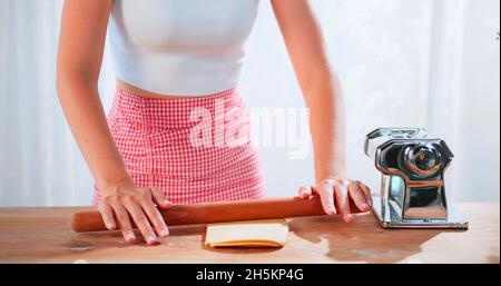 Une femme utilise une broche sur les pâtes Banque D'Images