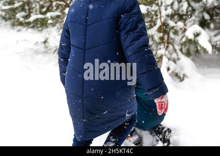 Enfants amusants à Winter Park jouant des boules de neige, passant du temps à l'extérieur.Forêt enneigée en hiver.Arrière-plan naturel de pin.Dégel froid Banque D'Images