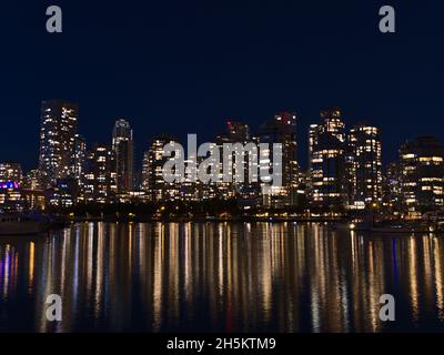Vue nocturne de Vancouver Skyline, Colombie-Britannique, Canada au centre-ville avec lumières de bâtiments illuminés en hauteur reflétés dans l'eau douce. Banque D'Images