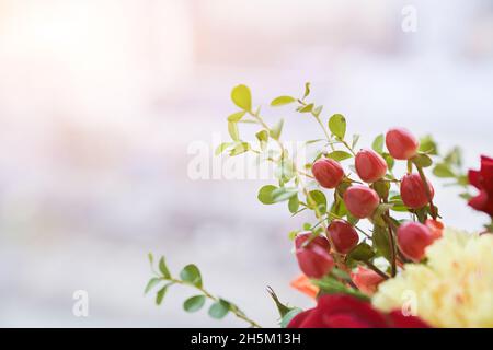 Partie du bouquet avec le bord des baies de barberge, feuilles vertes, rose rouge. Le concept des vacances. Copier l'espace. Photo de haute qualité Banque D'Images