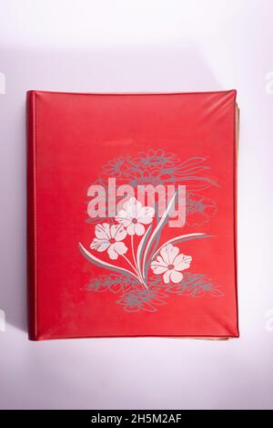 ancien album rouge avec fleurs sur fond blanc Banque D'Images