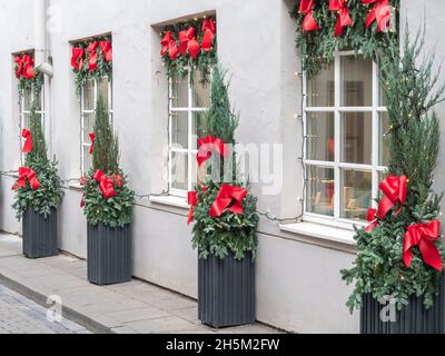 Façade du bâtiment décorée à Noël avec des branches de sapin de noël, des décorations et des guirlandes lumineuses Banque D'Images