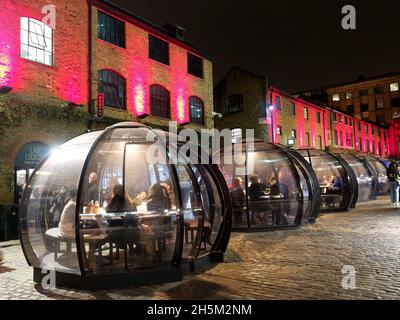 Vue nocturne des dîneurs mangeant dans les igloos à Camden Market à Londres Banque D'Images