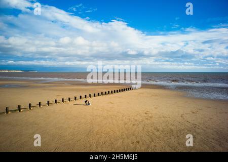 Une famille sur les sables du nord prenant une photo de groupe à marée basse à Bridlington Banque D'Images