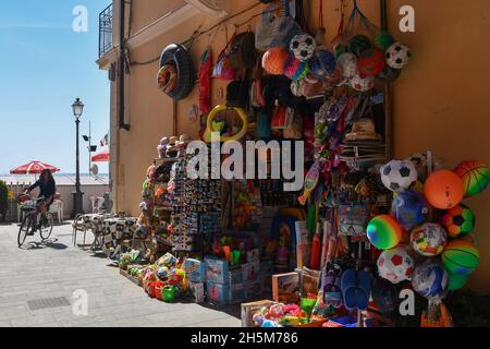 Une boutique touristique vendant des jouets et des souvenirs de plage sur le front de mer d'Alassio dans une belle journée d'été, Savona, Ligurie, Italie Banque D'Images