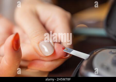 Femme test pour l'hyperglycémie.Femme tenant un dispositif pour mesurer le sucre dans le sang Banque D'Images