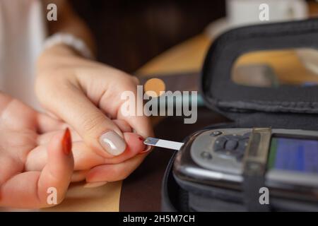 Femme test pour l'hyperglycémie.Femme tenant un dispositif pour mesurer le sucre dans le sang Banque D'Images