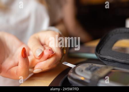 Femme test pour l'hyperglycémie.Femme tenant un dispositif pour mesurer le sucre dans le sang Banque D'Images