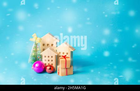 Maisons en bois, arbre de Noël et cadeaux.Préparation pour les vacances.Vacances d'hiver.Soldes de Noël.Remises nouvel an pour l'achat de logements.C'est vrai Banque D'Images