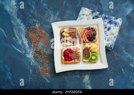 Assiette de délicieux sandwiches sucrés sur fond de couleur Banque D'Images