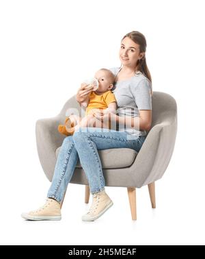 Jeune mère qui allaite bébé dans un fauteuil sur fond blanc Banque D'Images