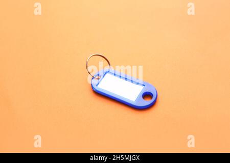 Étiquette de clé en plastique sur fond orange Banque D'Images